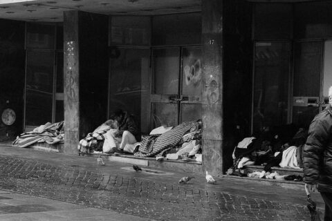 Black and White photograph of students sleeping outside in front of a large building